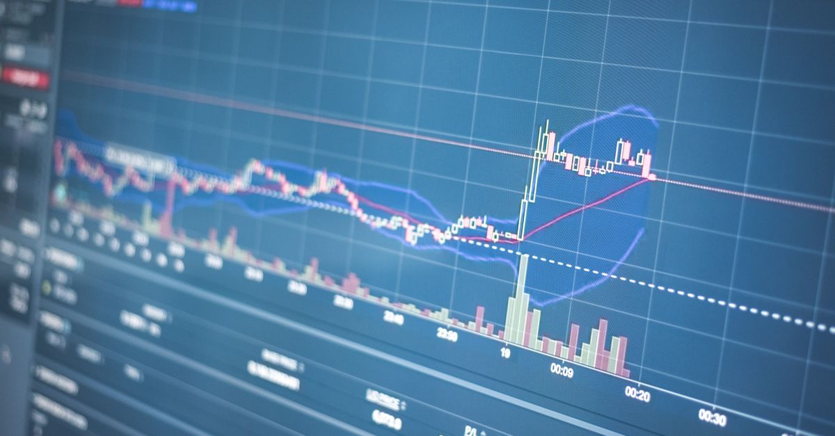 Pantalla con gráficos de datos financieros y líneas de tendencia sobre un escritorio